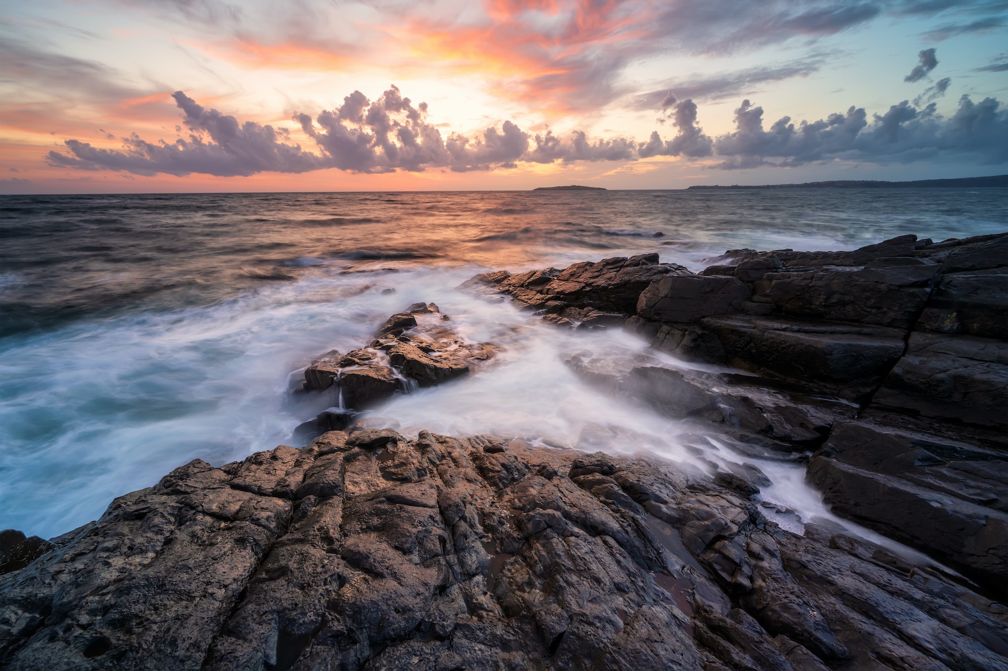 Sea sunrise at rocky beach